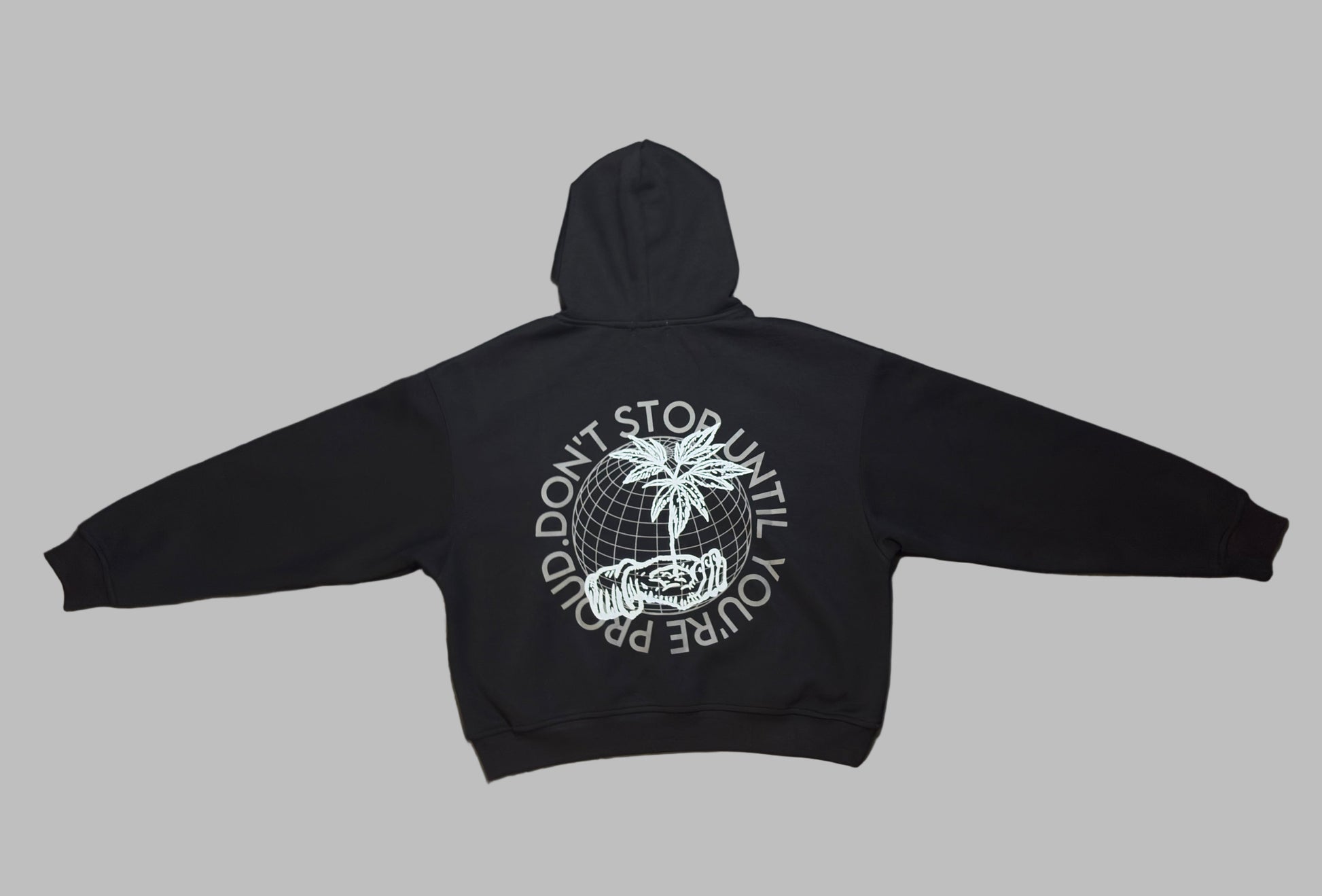 Black hoodie with a white graphic on the back, laid flat on a light-colored surface.