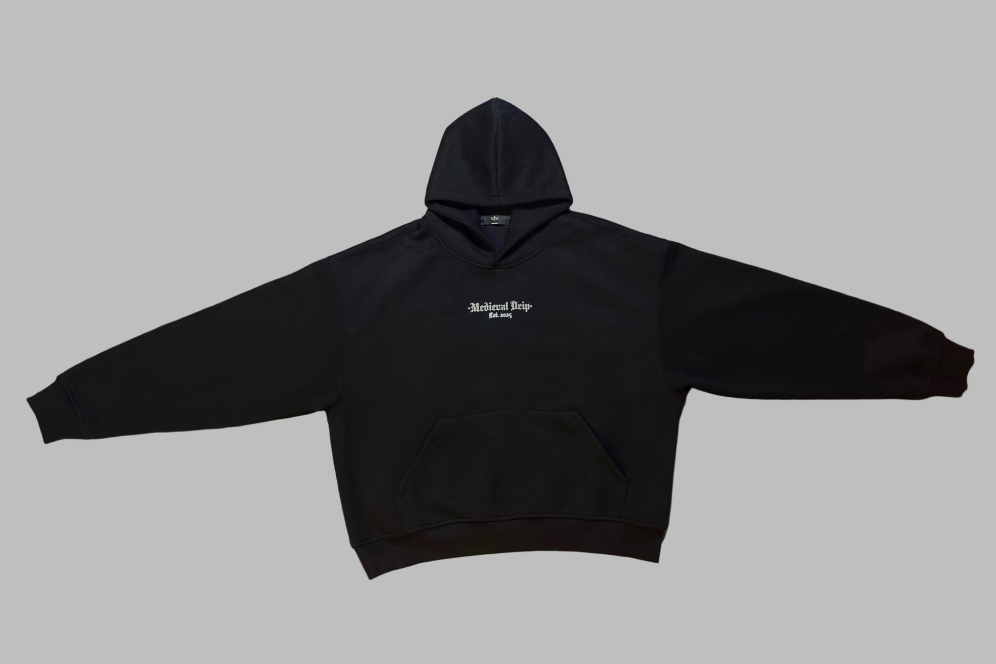 Black hoodie with a logo on a beige surface